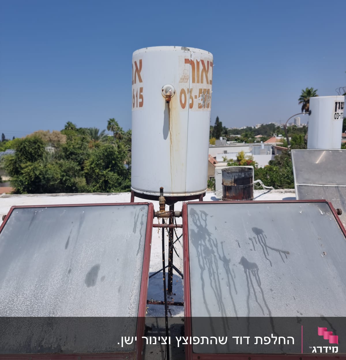 דוד שמש עם קולטים על גג תחת שמיים כחולים